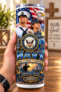Hand holding a straight-sided 20 oz tumbler with Patriotism Navy 2 artwork on a warm wood counter