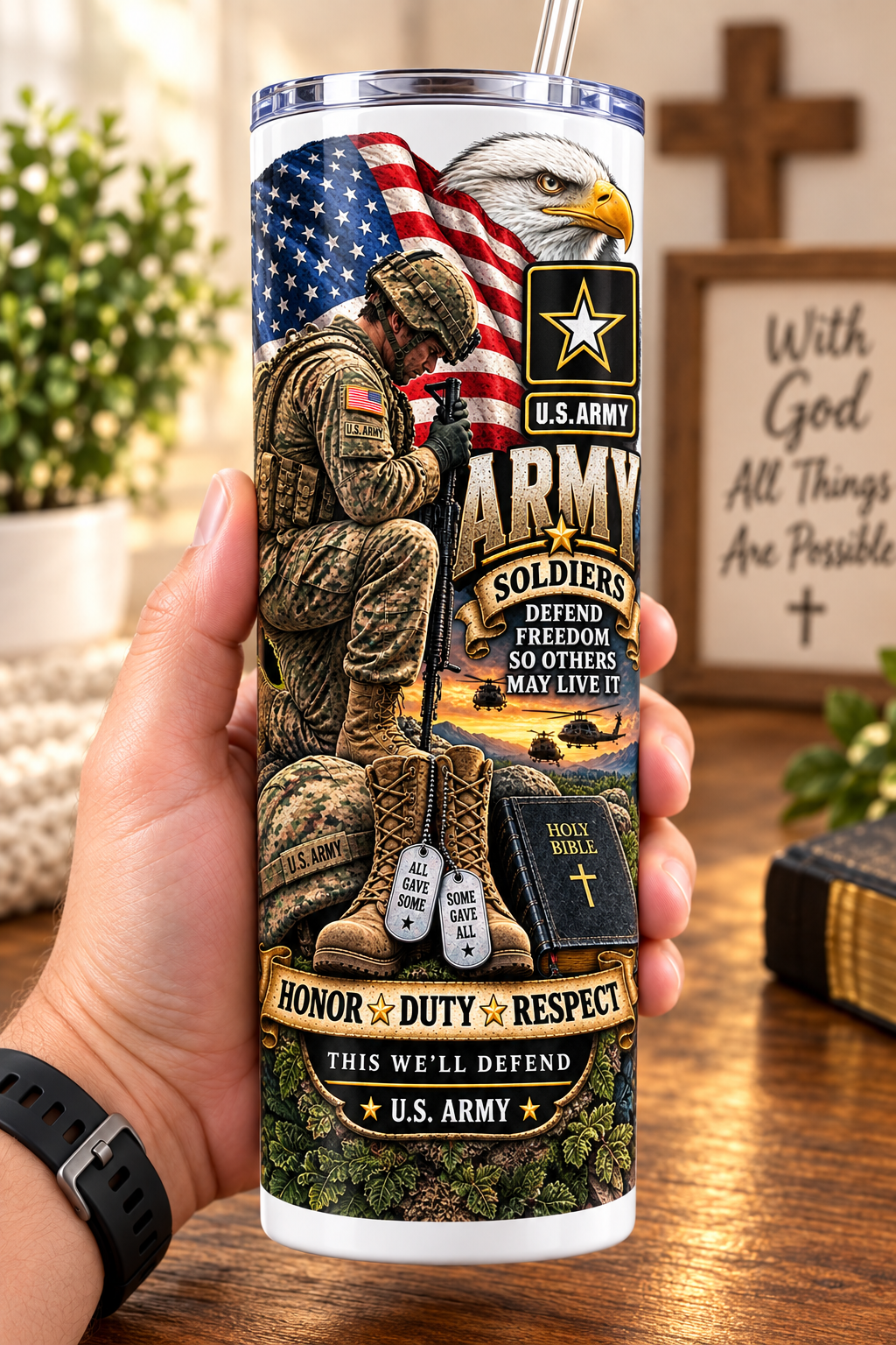 Hand holding a straight-sided 20 oz tumbler with Patriotism Army 1 artwork on a warm wood counter